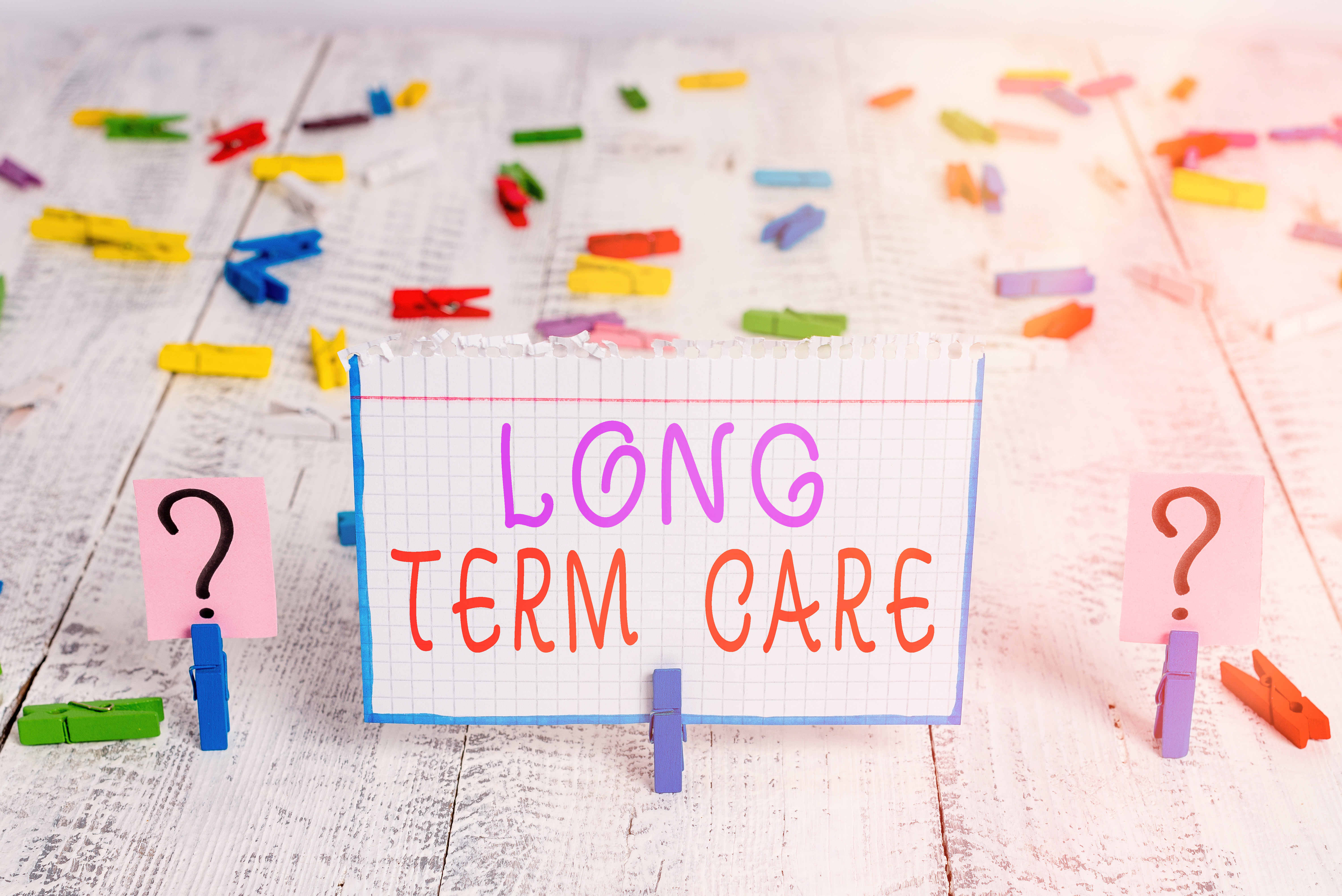 Conceptual hand writing showing Long Term Care. Business photo showcasing assistance with the basic an individualal tasks of everyday life Crumbling sheet with paper clips placed on the wooden table.