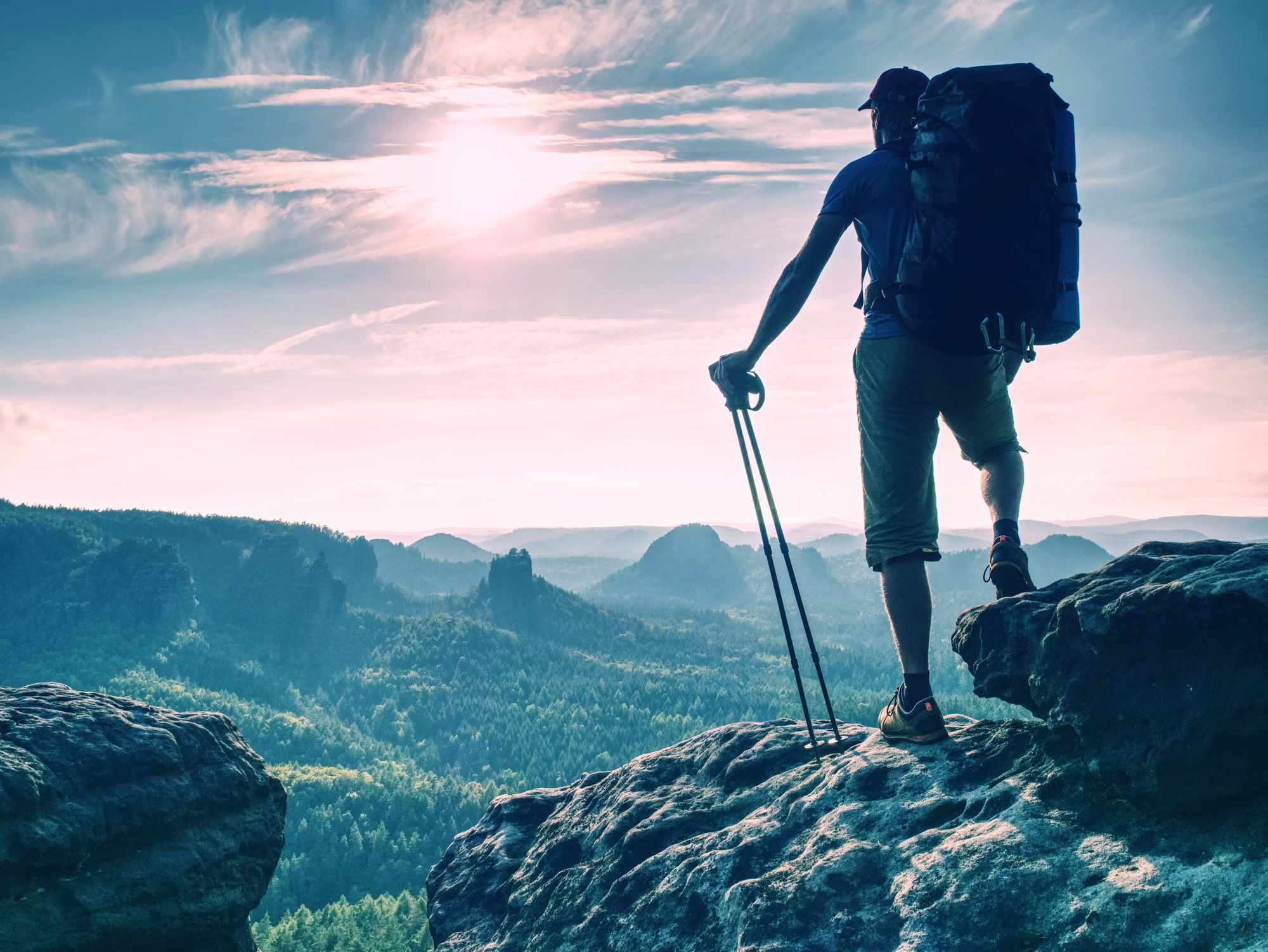 image of hiker at the top of a mountain looking onto a beautiful view